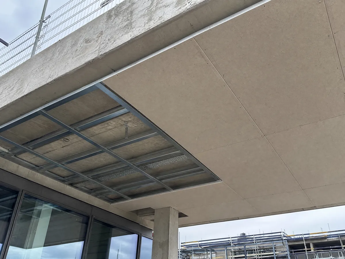 Steel suspended ceiling grid with cement boards fitted under a concrete soffit