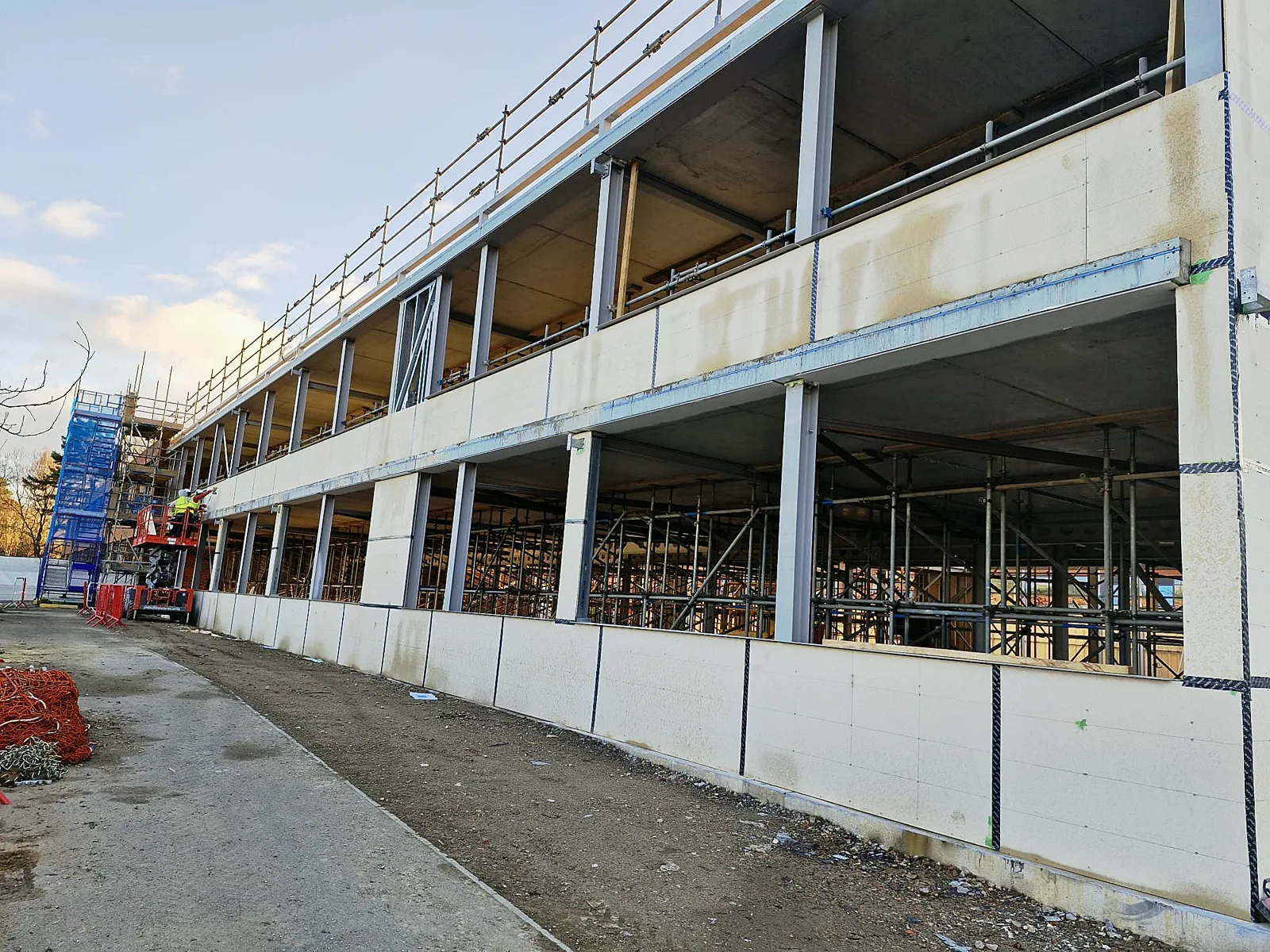 Three-storey steel frame building faced with boards along its external wall