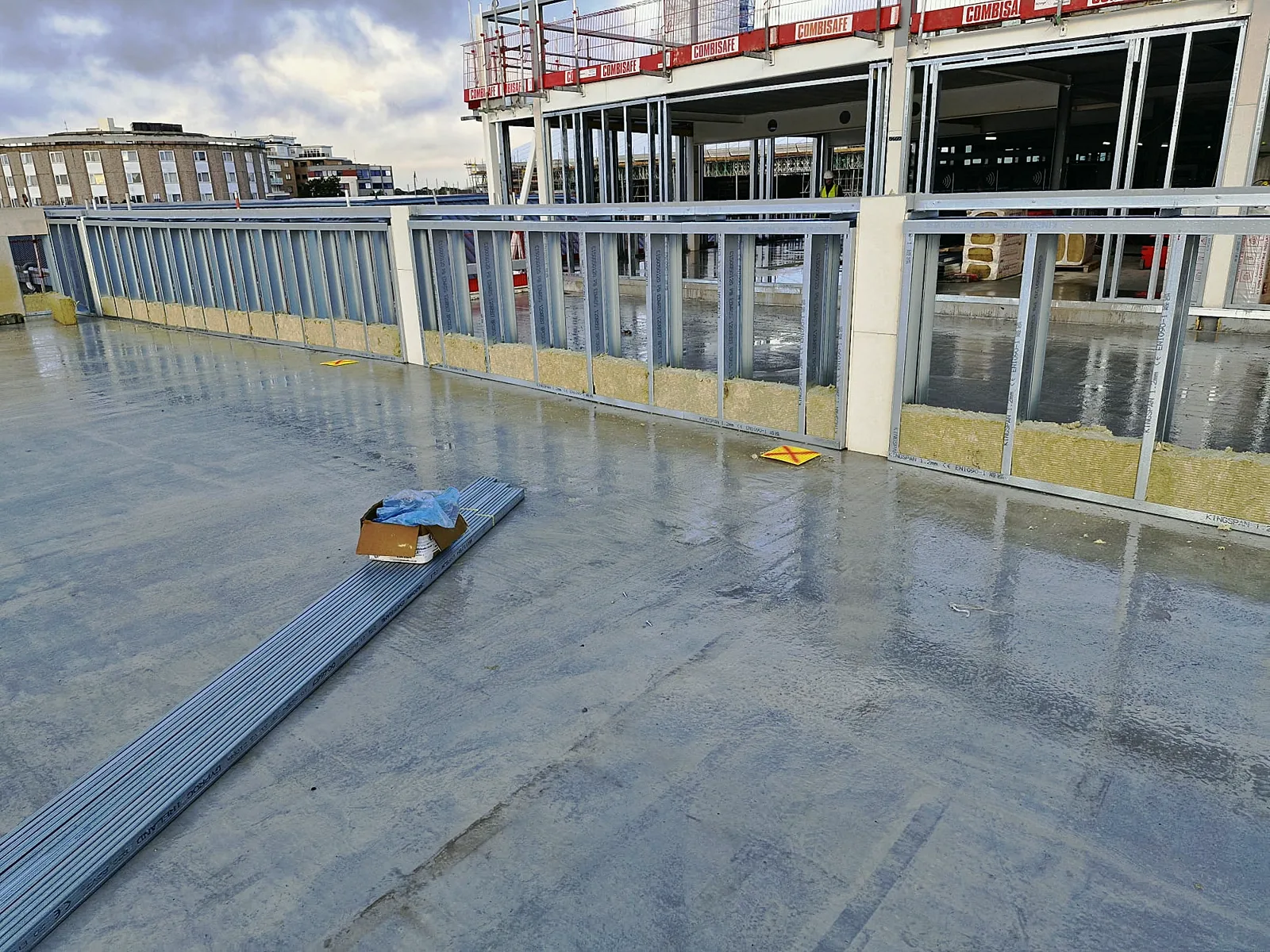 Steel stud framing with mineral wool insulation on a concrete floor slab