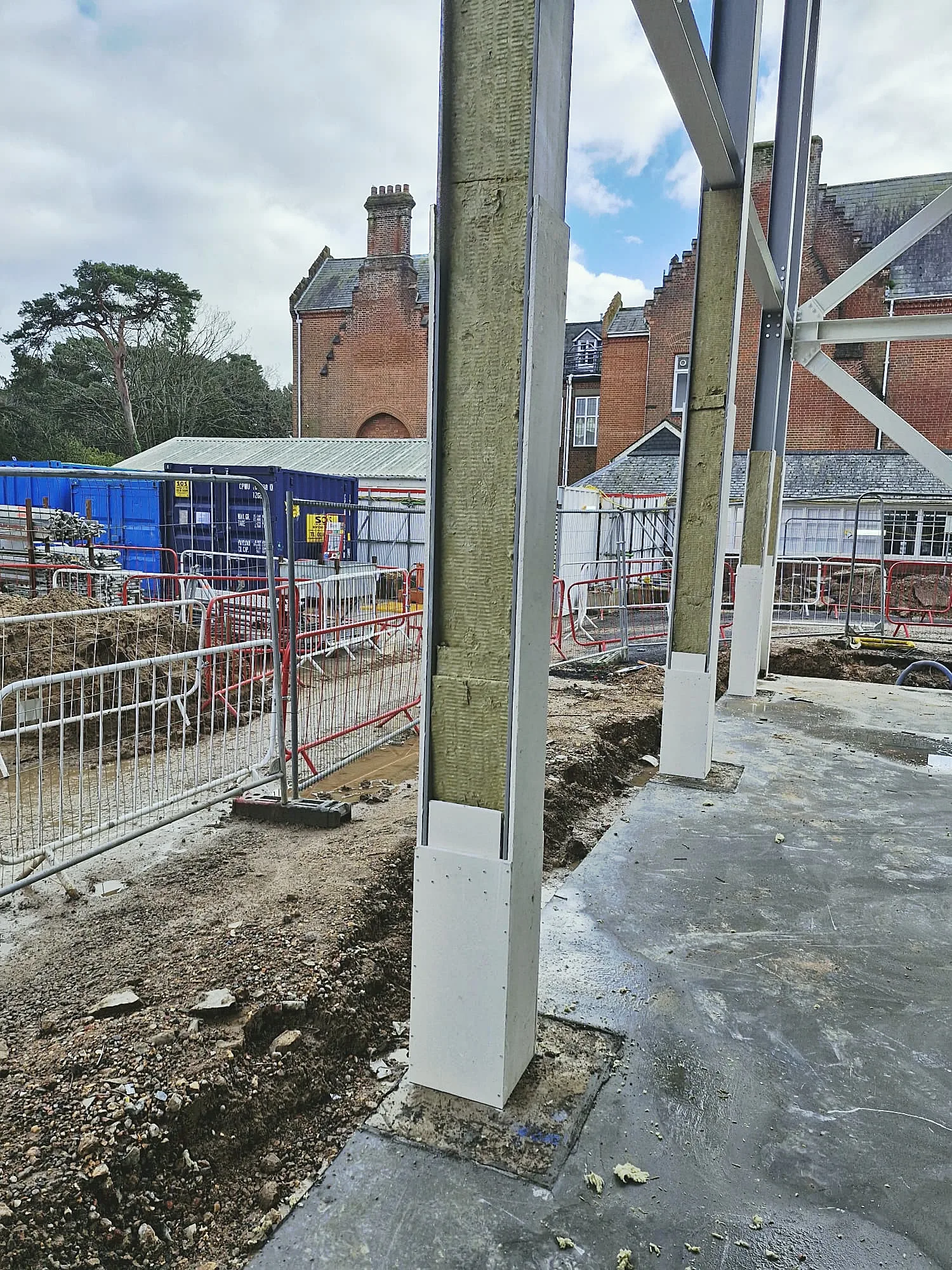 Steel columns wrapped in mineral wool with board protection at the base