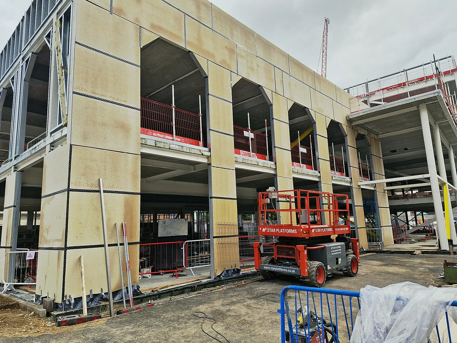 Two-storey external wall faced with boards and taped joints around arched openings